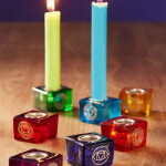 Chakra Glas und Messing Kerzenhalter – spirituelles Licht für Harmonie Dieser farbenfrohe Chakra Kerzenhalter aus recyceltem Glas und Messing vereint traditionelle Symbolik mit dekorativer Schönheit. Jeder der 7 Chakren wird durch seine charakteristische Farbe und ein filigranes Metallsymboldargestellt. Ein zentrales Metalltablett im Inneren sorgt dafür, dass die Kerze sicher steht.